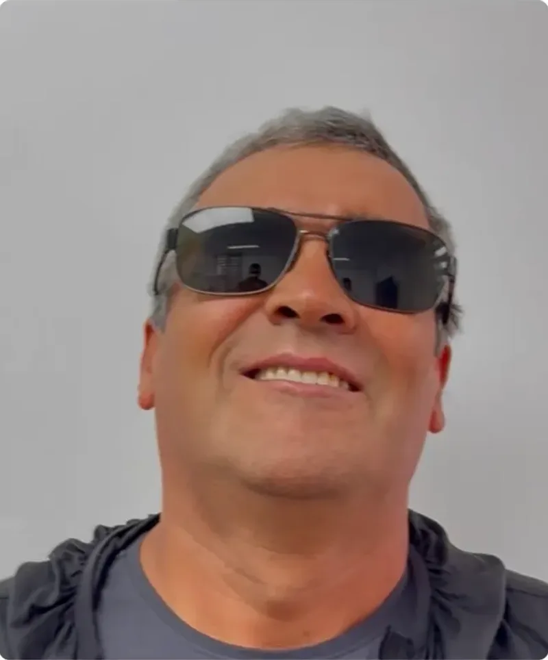 El mismo paciente sonriendo tras la rehabilitación, con la arcada superior completa